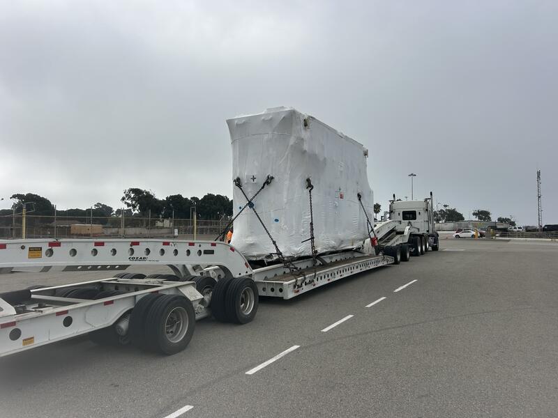 154,324 lb power transformer chained down on a multi axle lowboy trailer behind a heavy haul tractor