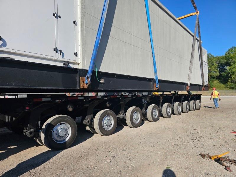 Close view of the multi axle trailer suspension and lifting slings supporting the 98,000 lb data center module