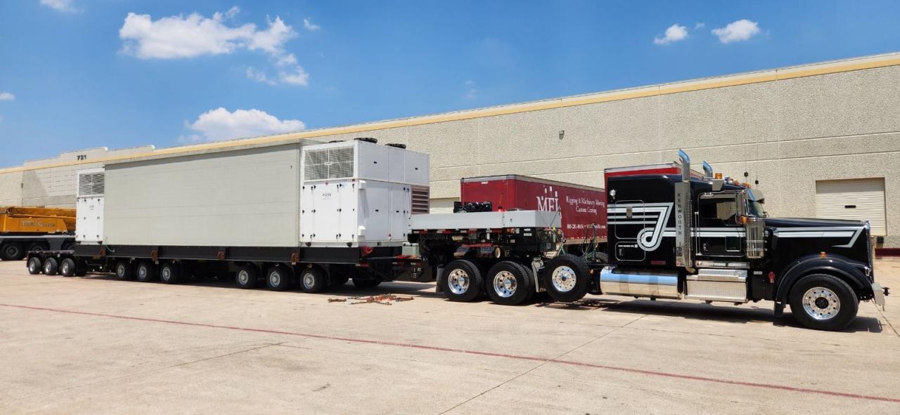 2024 Gen2 mission critical data center module loaded on a multi axle perimeter frame trailer behind a black Kenworth heavy haul tractor