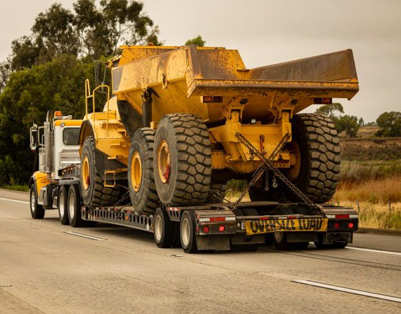 Excavator and heavy construction equipment loaded for jobsite transport
